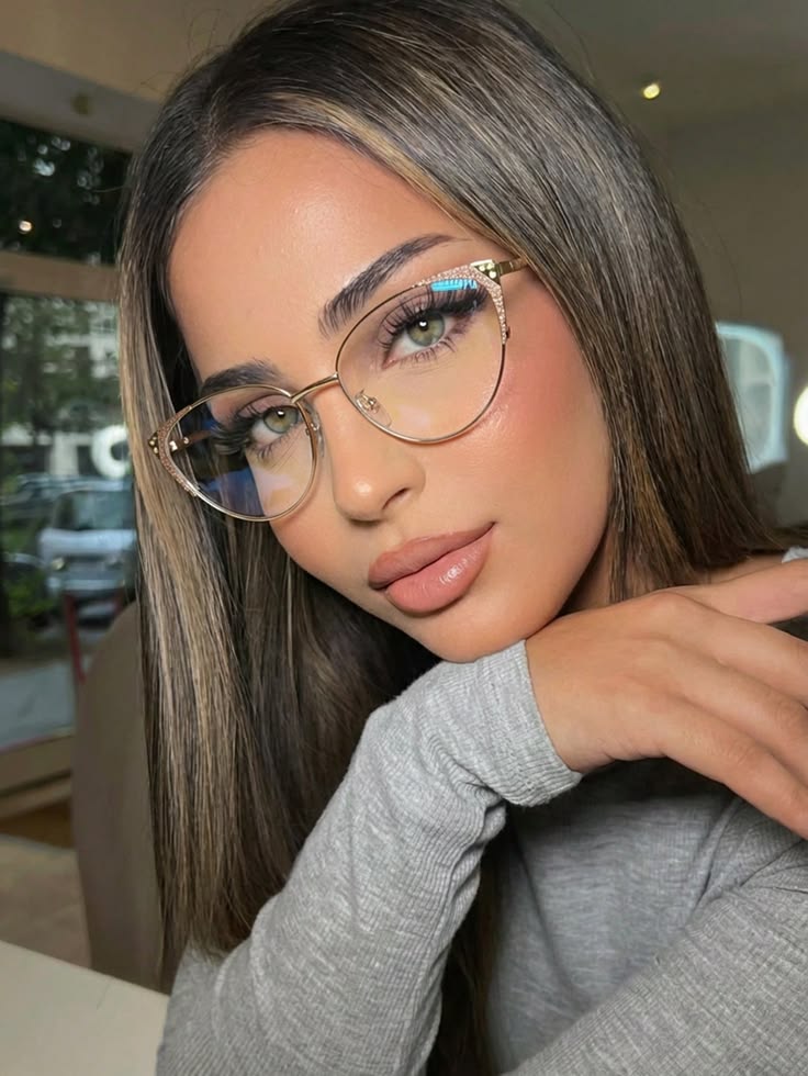 Mujer con armazón cat-eye dorado con detalles brillantes